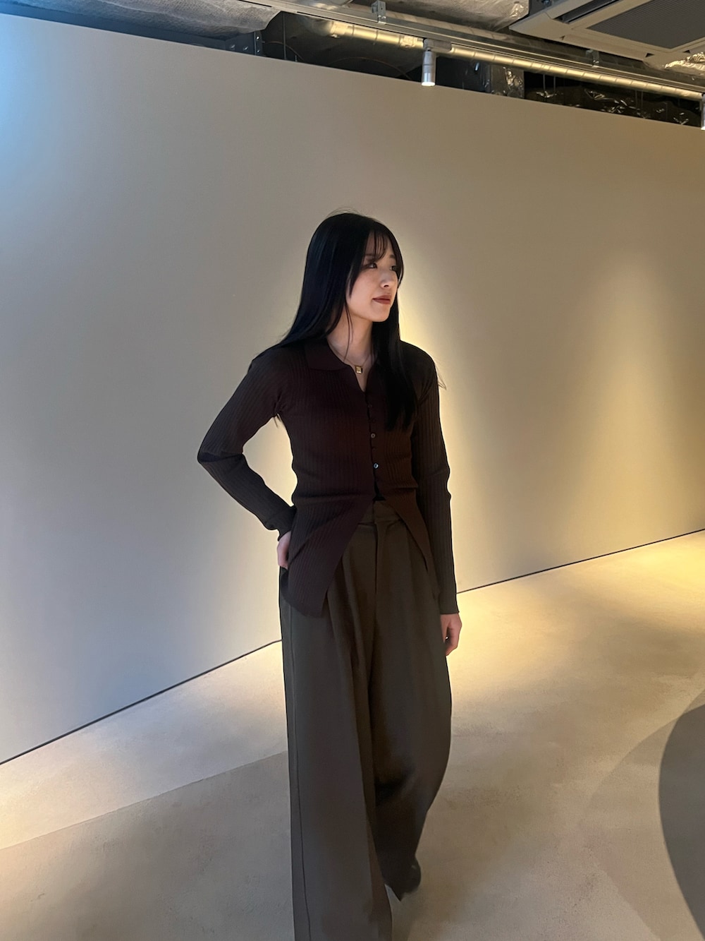 ブラウン系のカーディガン/ボレロ、ブラウン系のスラックスを着用したレディースの冬コーディネートの2枚目の写真