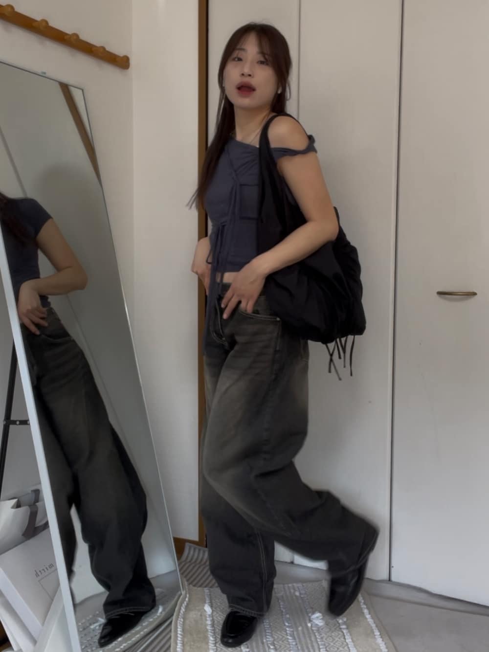 ブラック系のデニムパンツ、グレー系のTシャツ/カットソー、ブラック系のショルダーバッグを着用したレディースの夏コーディネートの2枚目の写真