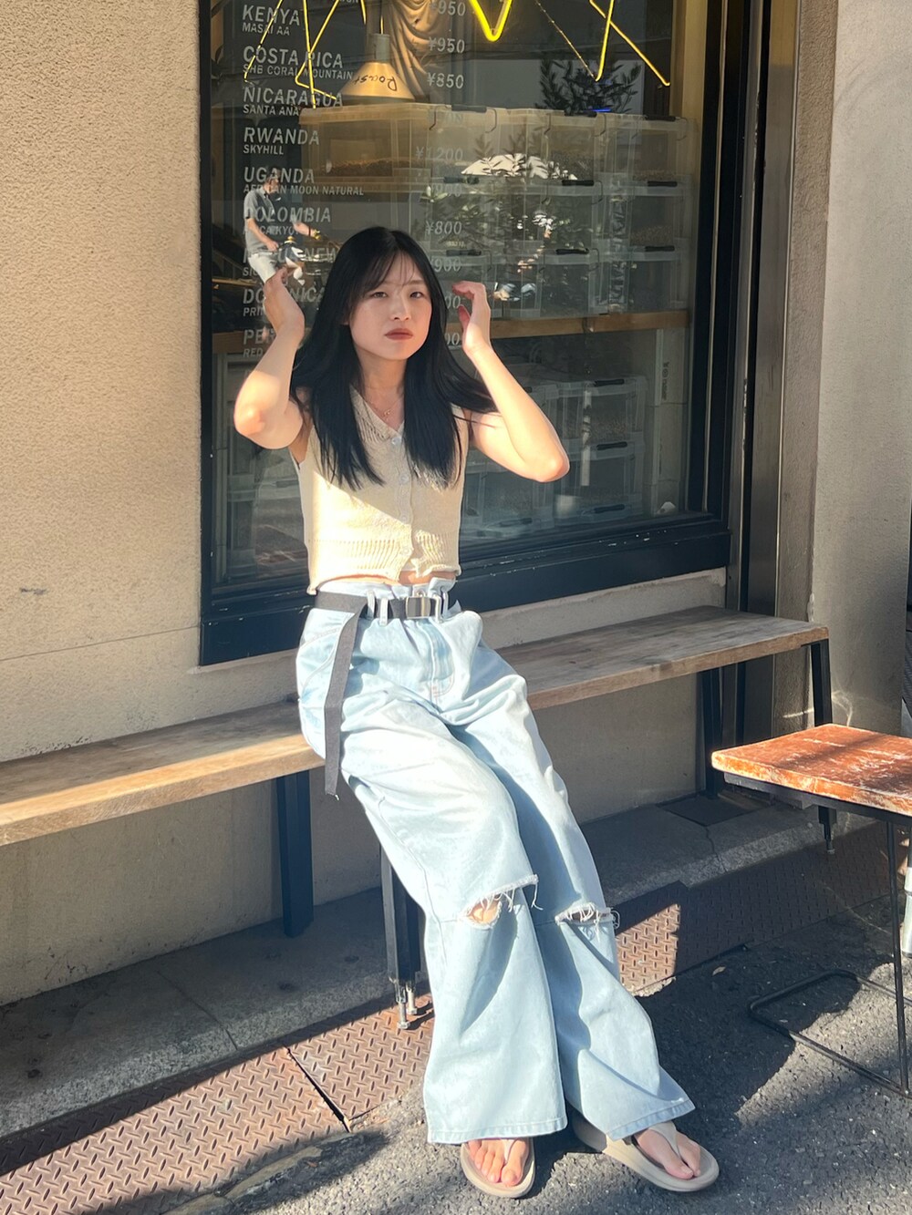 ブルー系のデニムパンツ、ベージュ系のサンダル、ベージュ系のトップスを着用したレディースの夏コーディネートの2枚目の写真