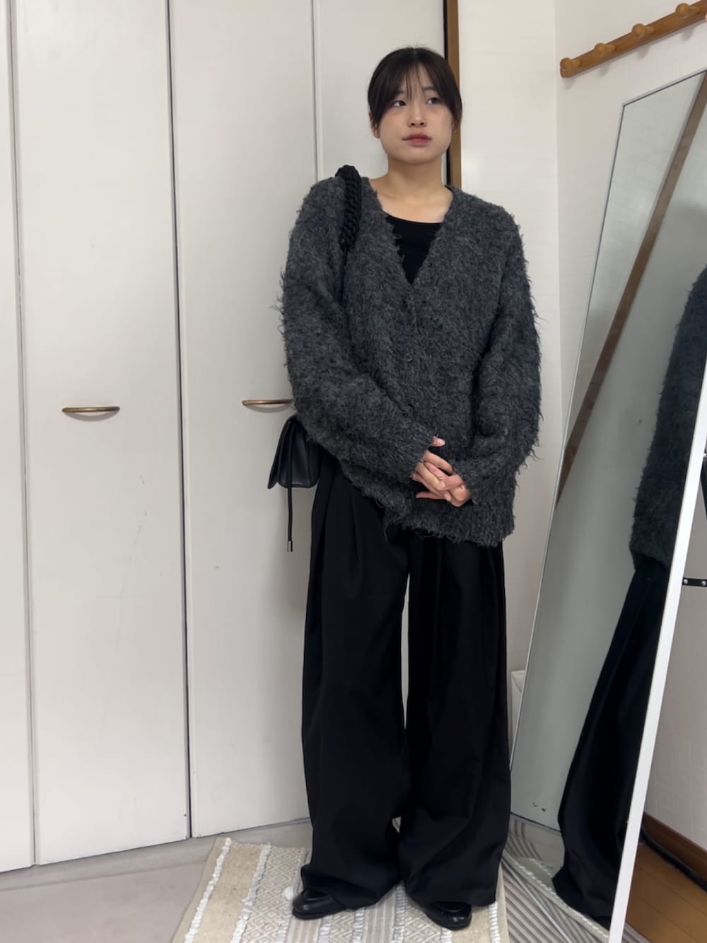 グレー系のカーディガン/ボレロ、ブラック系のスラックス、ブラック系のショルダーバッグを着用したレディースの秋コーディネートの2枚目の写真