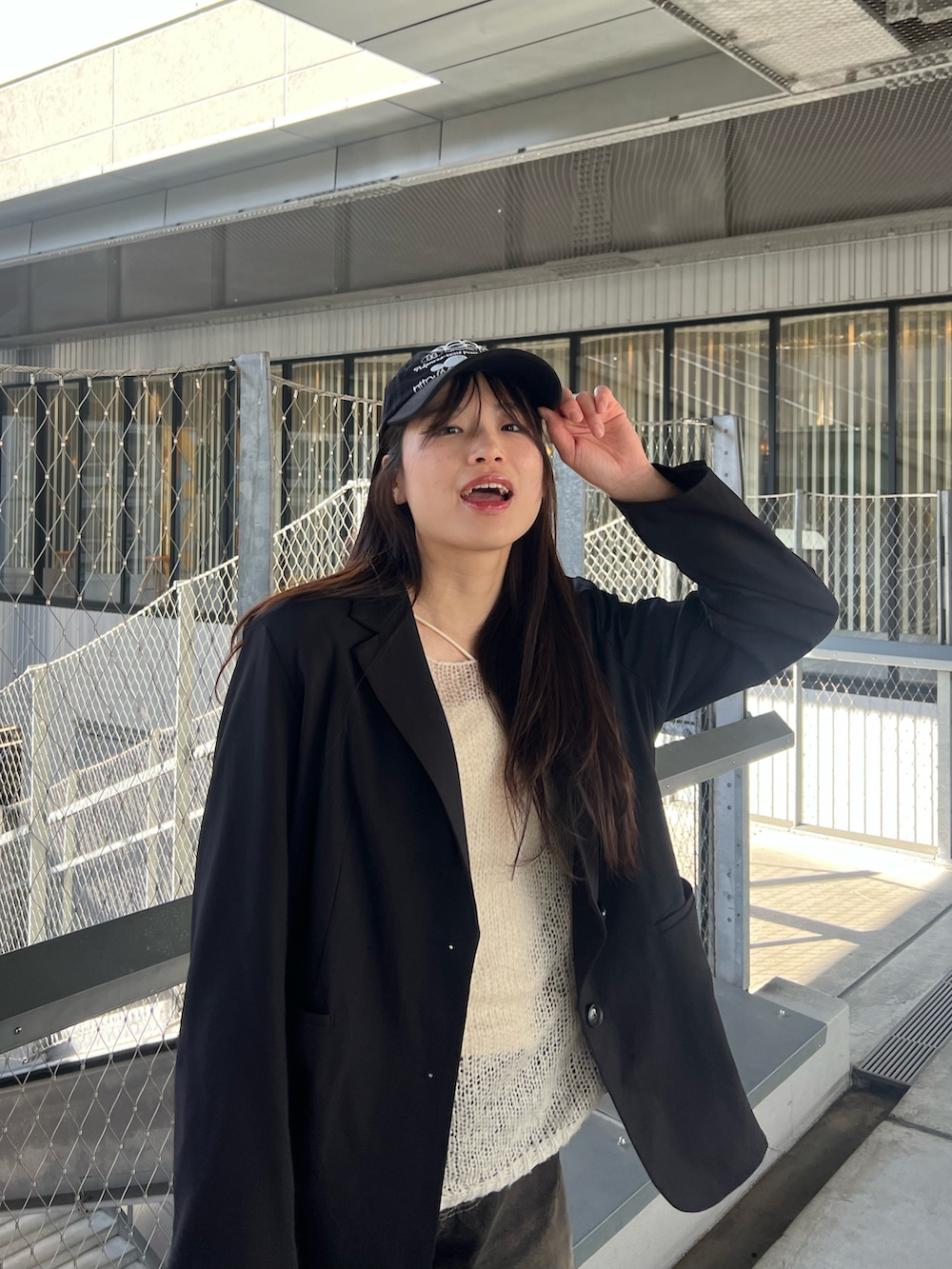 ホワイト系のニット/セーター、ブラック系のテーラードジャケット、ブラック系のデニムパンツを着用したレディースの春コーディネートの2枚目の写真