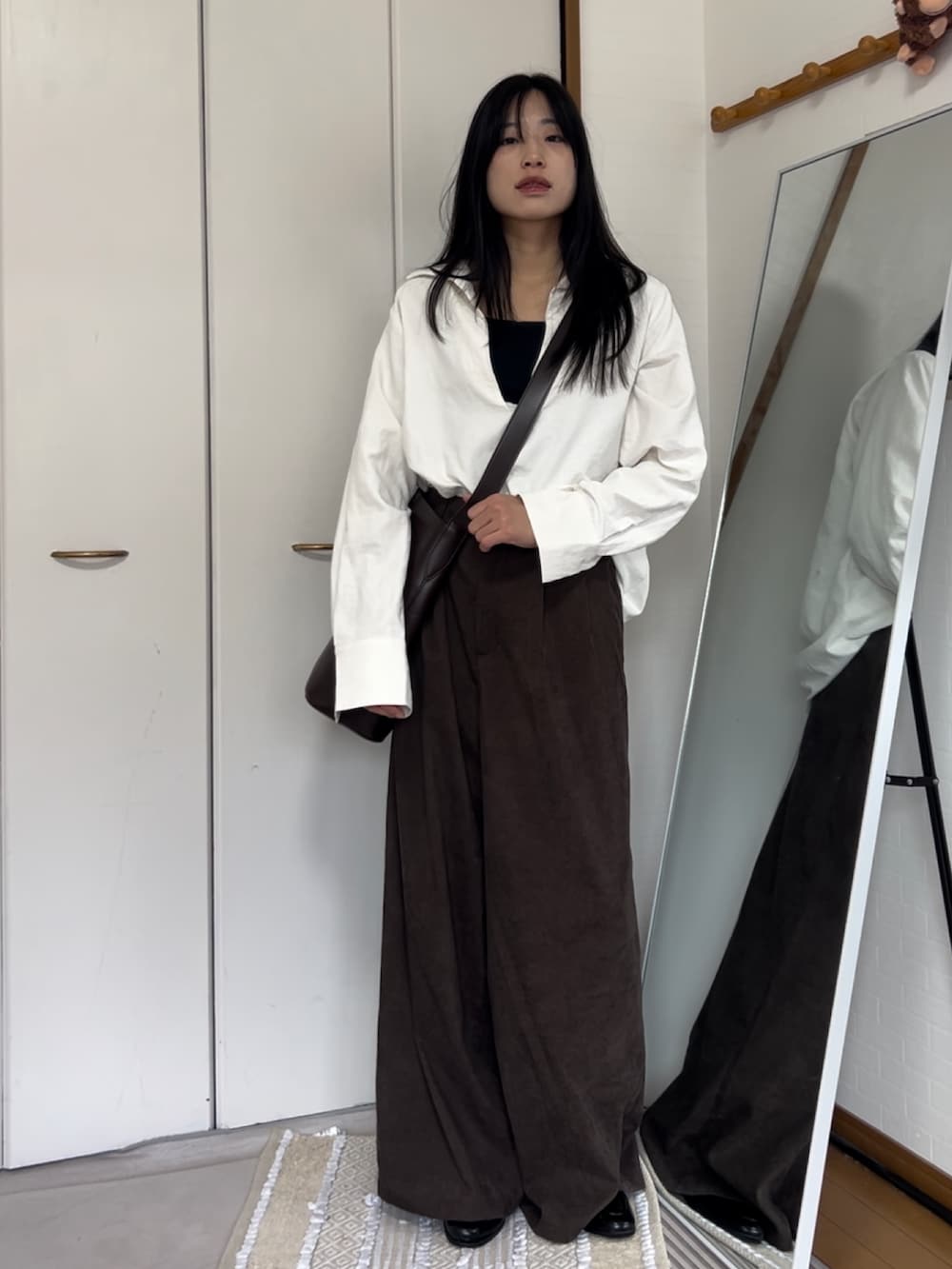 ホワイト系のシャツ/ブラウス、ブラウン系のスラックス、ブラウン系のバッグを着用したレディースの秋コーディネートの2枚目の写真