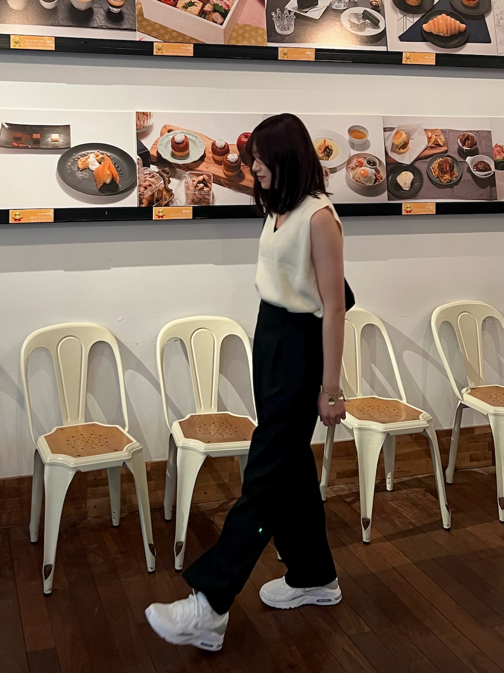 ベージュ系のベスト、ブラック系のスラックス、ホワイト系のスニーカーを着用したレディースの夏コーディネートの3枚目の写真