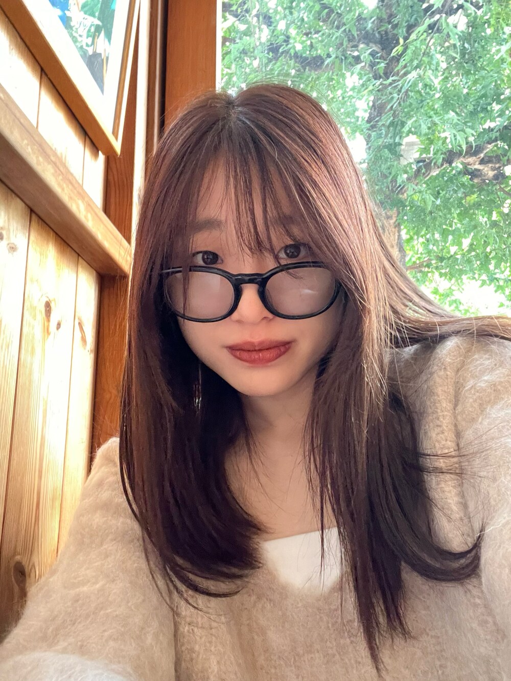 ベージュ系のニット/セーター、ブラック系のスカート、レッド系のトートバッグを着用したレディースの秋コーディネートの2枚目の写真