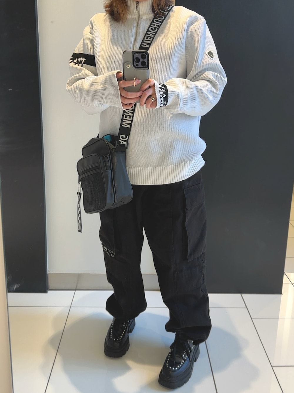 ブラック系のカーゴパンツ、ホワイト系のニット/セーター、ブラック系のローファーを着用したレディースの冬コーディネートの2枚目の写真