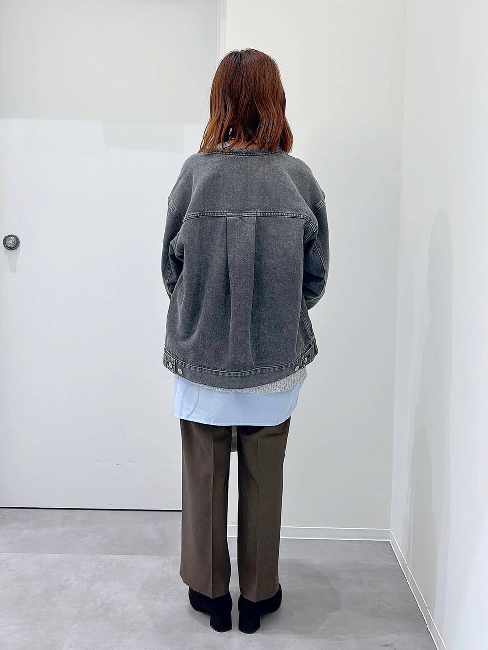 ブラック系のローファー、ブラウン系のスラックス、グレー系のデニムジャケットを着用したレディースの秋コーディネートの3枚目の写真