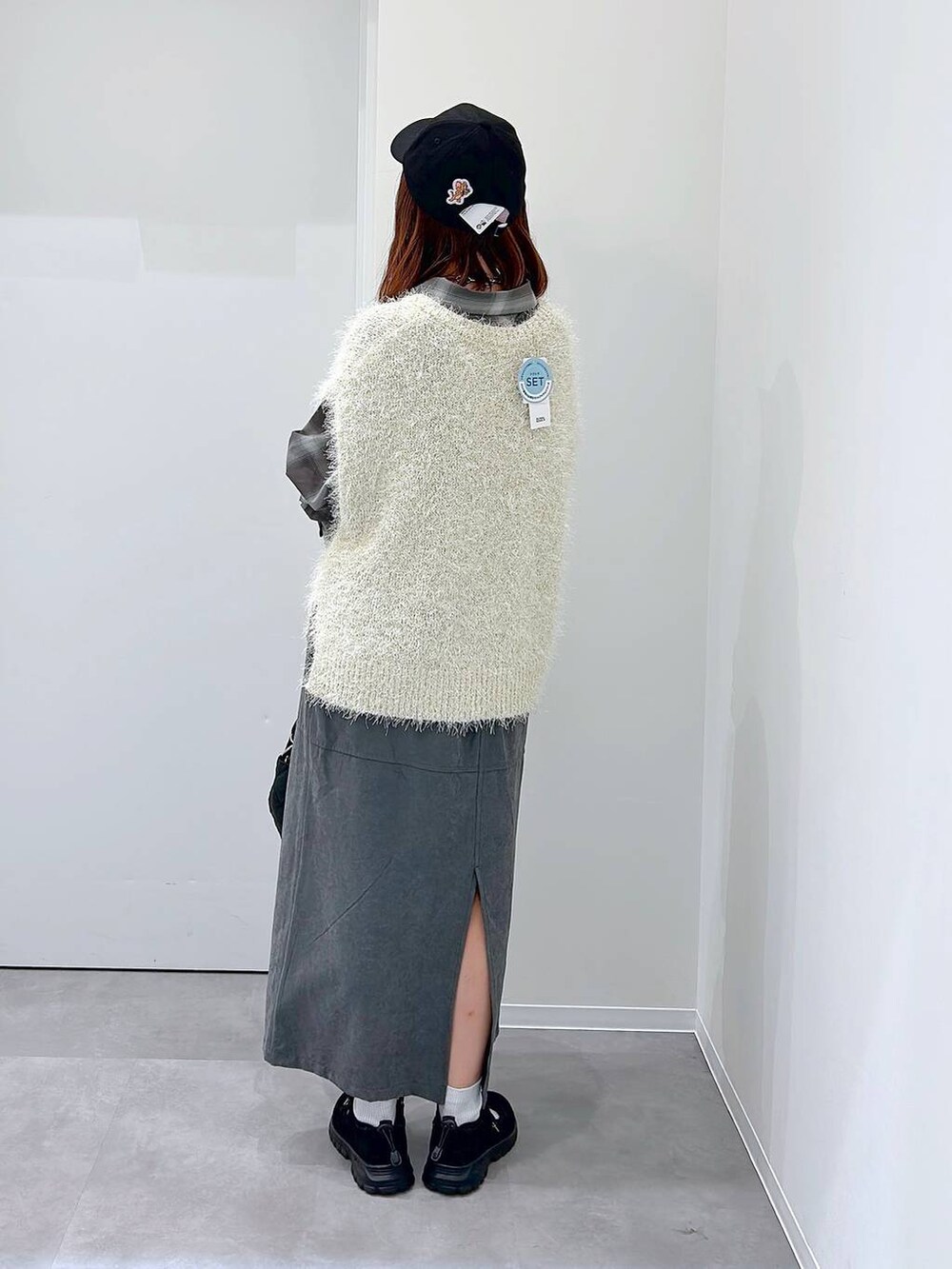 ブラック系のスニーカー、ブラック系のボストンバッグ、ブラウン系のシャツ/ブラウスを着用したレディースの秋コーディネートの3枚目の写真