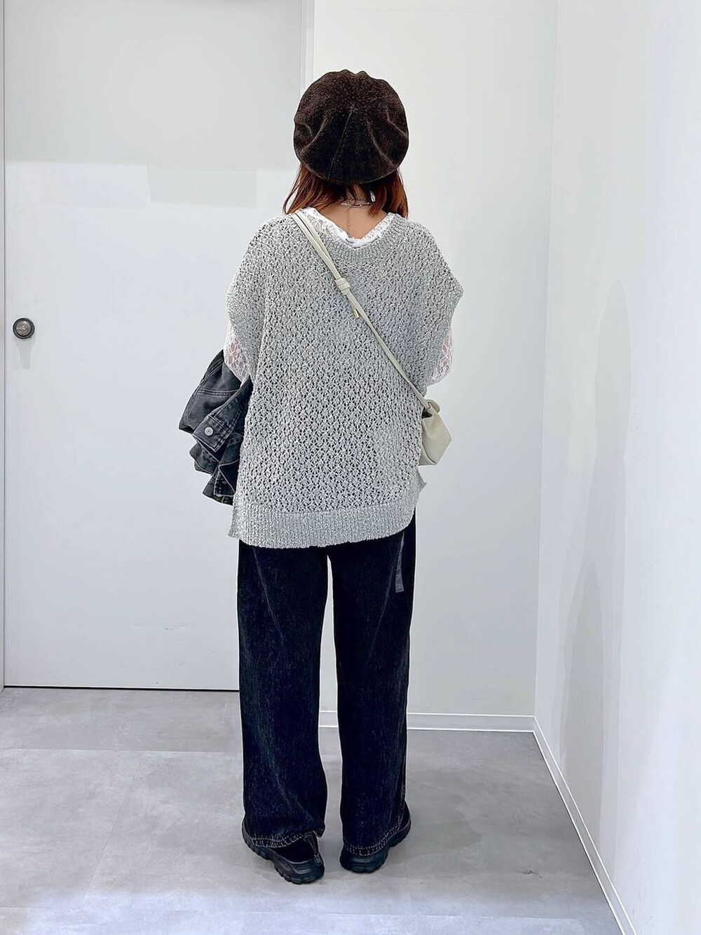 ブラック系のスニーカー、ブラック系のデニムパンツ、グレー系のデニムジャケットを着用したレディースの秋コーディネートの3枚目の写真