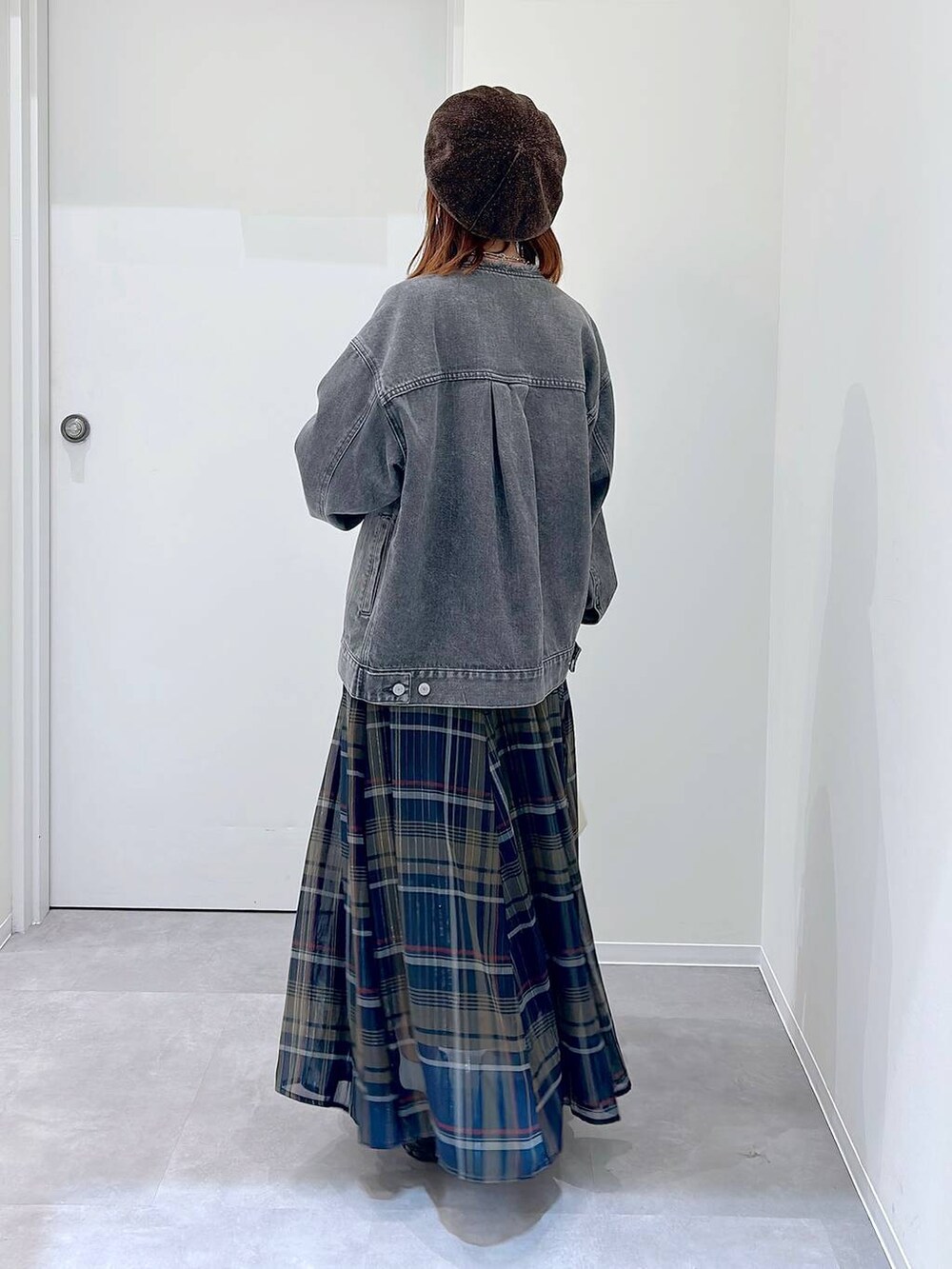 ブラック系のスニーカー、グレー系のデニムジャケット、その他のスカートを着用したレディースの秋コーディネートの3枚目の写真