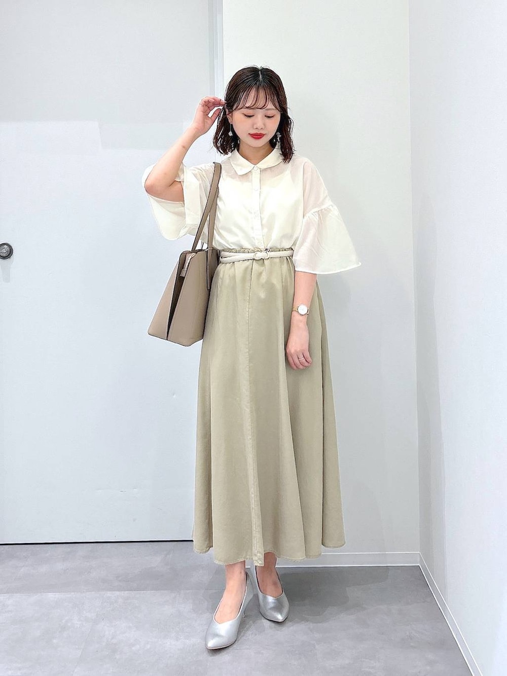ベージュ系のトートバッグ、シルバー系のパンプス、ベージュ系のスカートを着用したレディースの夏コーディネートの4枚目の写真