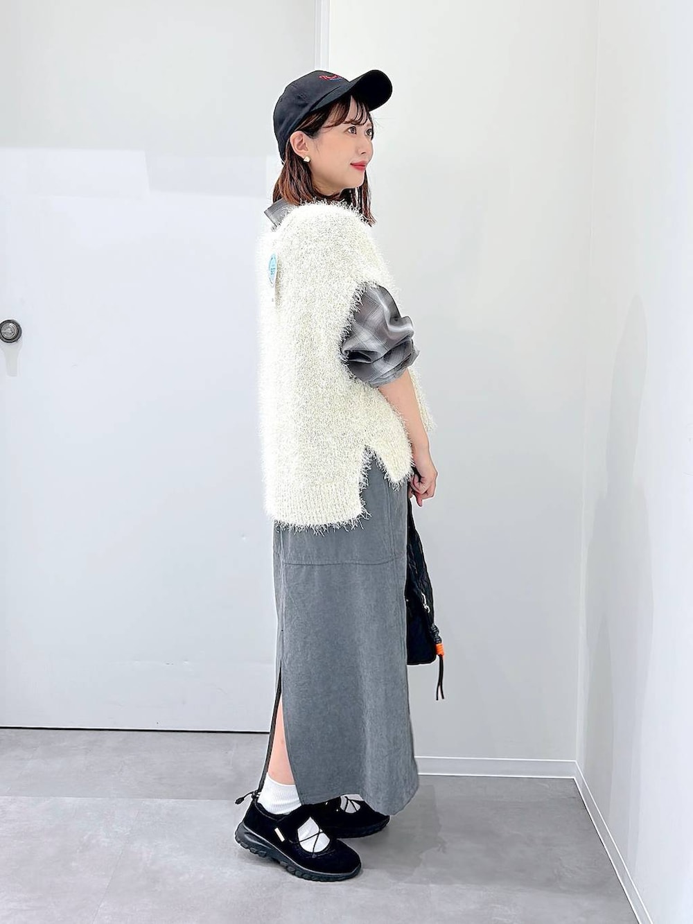 ブラック系のスニーカー、ブラック系のボストンバッグ、ブラウン系のシャツ/ブラウスを着用したレディースの秋コーディネートの2枚目の写真