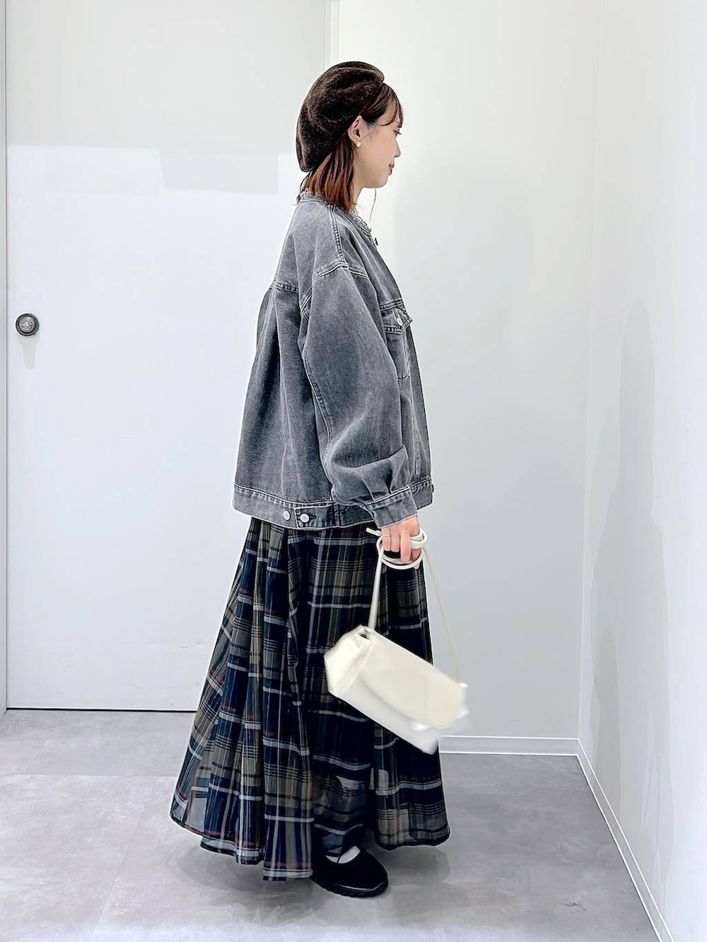 ブラック系のスニーカー、グレー系のデニムジャケット、その他のスカートを着用したレディースの秋コーディネートの2枚目の写真