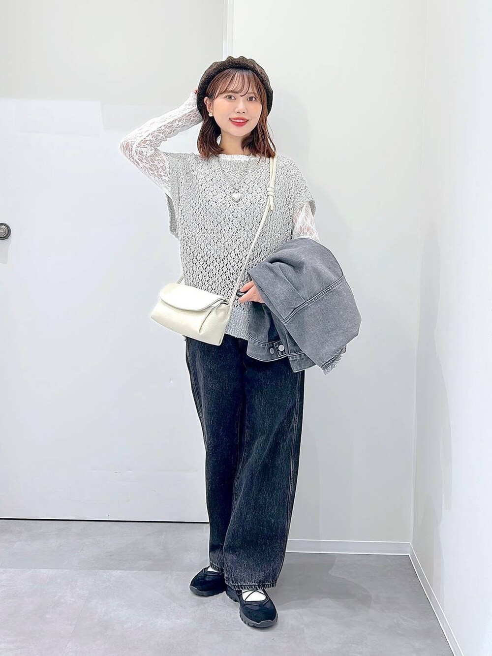 ブラック系のスニーカー、ブラック系のデニムパンツ、グレー系のデニムジャケットを着用したレディースの秋コーディネートの4枚目の写真