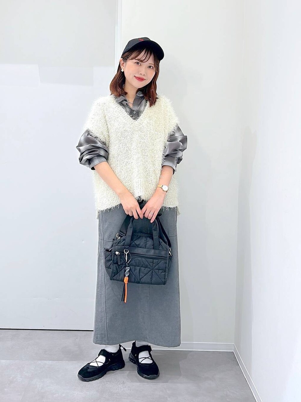 ブラック系のスニーカー、ブラック系のボストンバッグ、ブラウン系のシャツ/ブラウスを着用したレディースの秋コーディネートの4枚目の写真