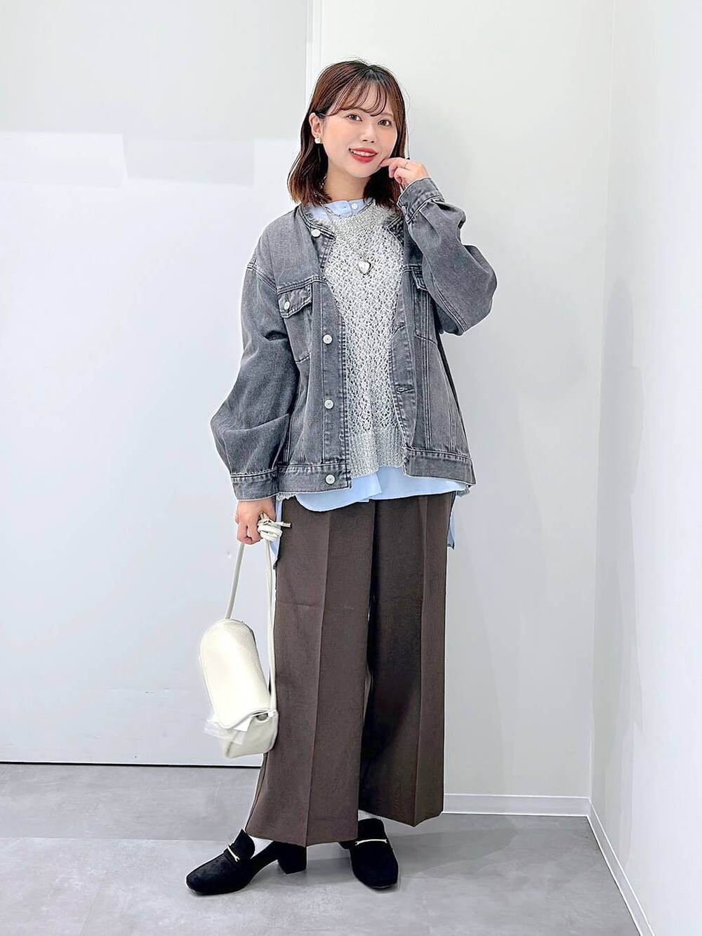 ブラック系のローファー、ブラウン系のスラックス、グレー系のデニムジャケットを着用したレディースの秋コーディネートの4枚目の写真