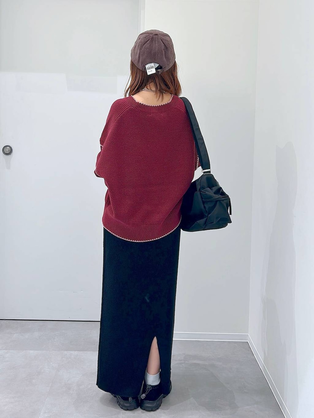 ブラック系のスニーカー、ブラック系のショルダーバッグ、レッド系のカーディガン/ボレロを着用したレディースの秋コーディネートの3枚目の写真