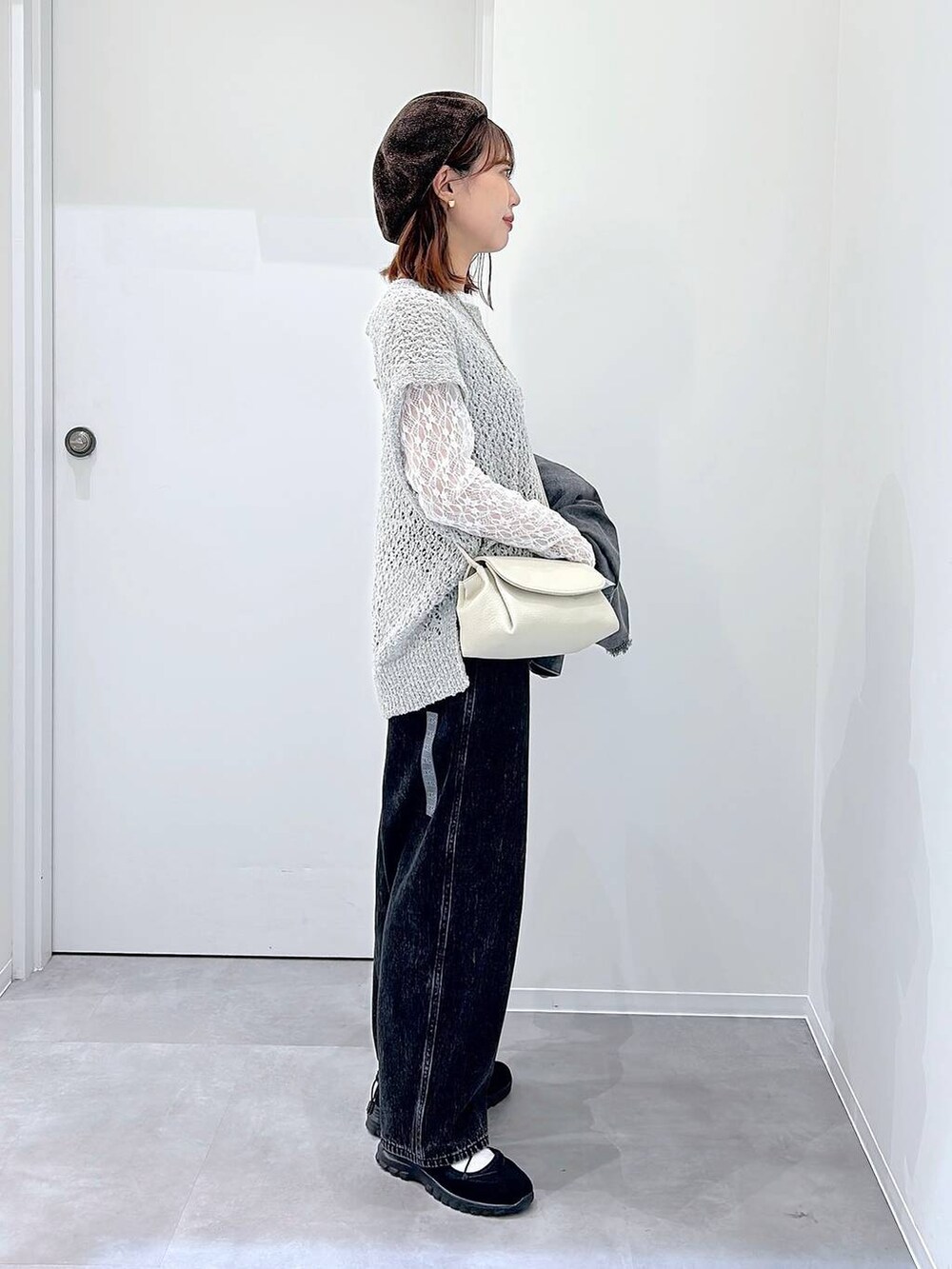 ブラック系のスニーカー、ブラック系のデニムパンツ、グレー系のデニムジャケットを着用したレディースの秋コーディネートの2枚目の写真