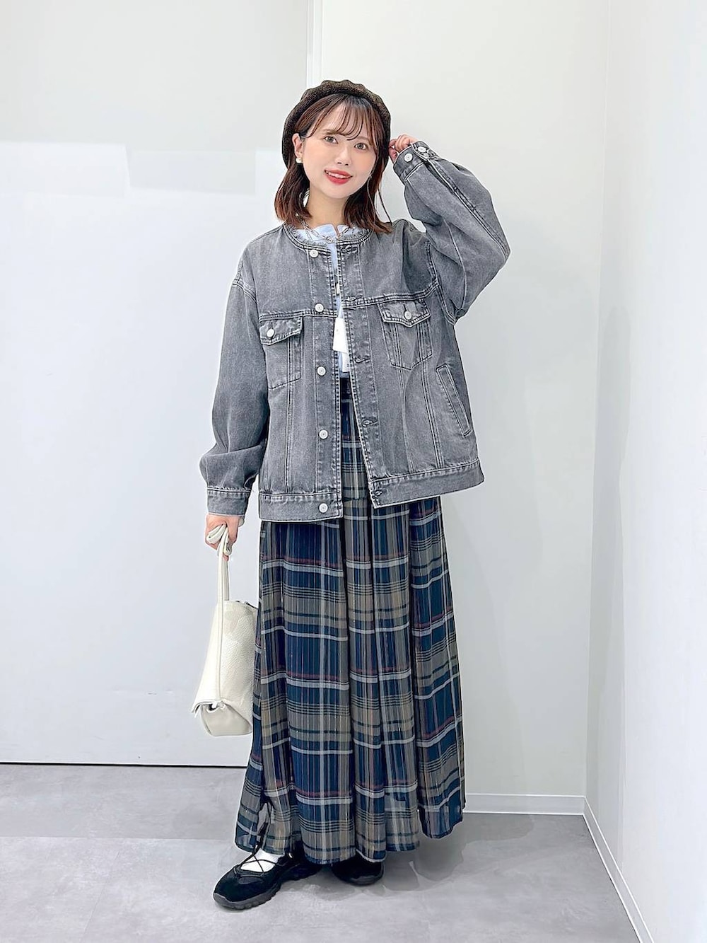 ブラック系のスニーカー、グレー系のデニムジャケット、その他のスカートを着用したレディースの秋コーディネートの4枚目の写真