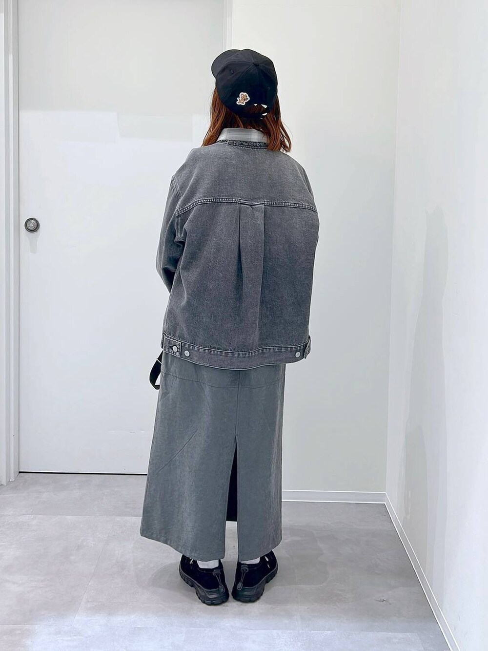 ブラック系のスニーカー、グレー系のデニムジャケット、ブラック系のボストンバッグを着用したレディースの秋コーディネートの3枚目の写真