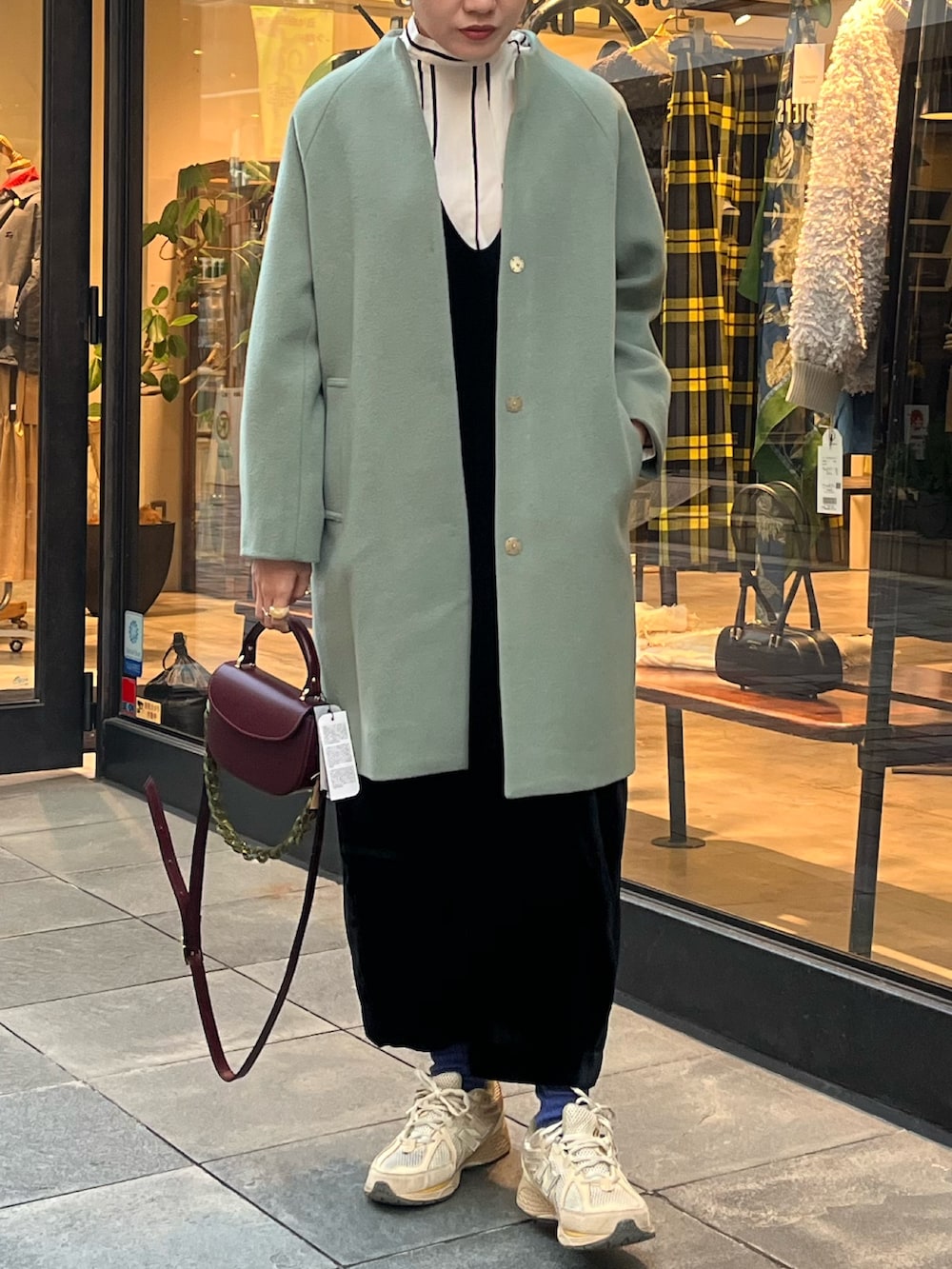 ブラック系のワンピース、ホワイト系のシャツ/ブラウス、グリーン系のその他アウターを着用したレディースの秋コーディネートの2枚目の写真