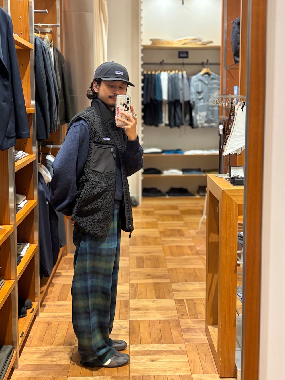 ブラック系のベスト、ブルー系のスウェット、グリーン系のその他パンツを着用したメンズの秋コーディネートの2枚目の写真