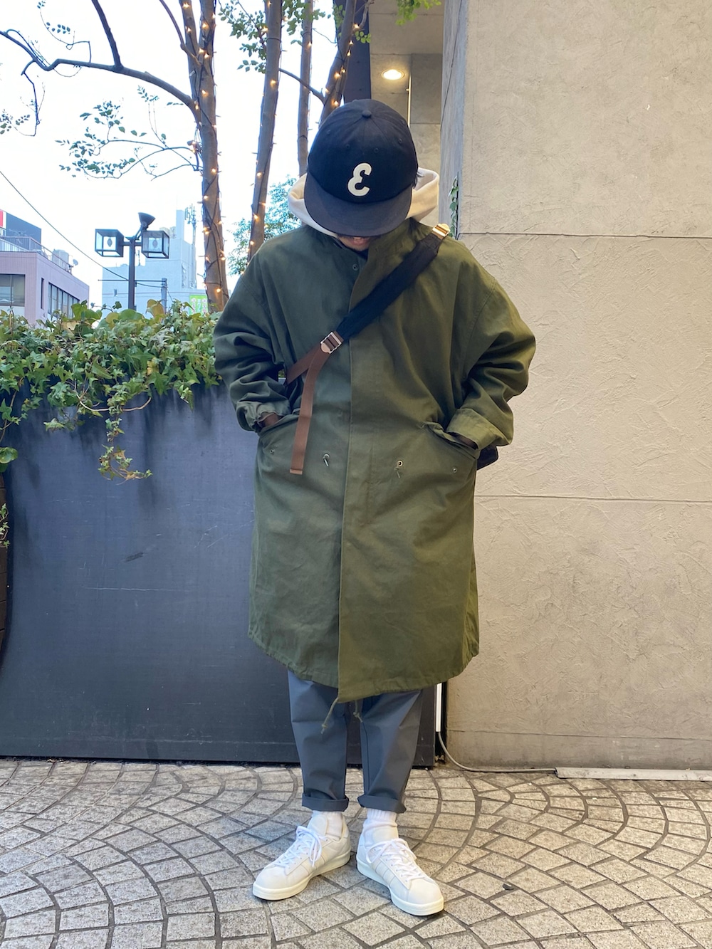 グレー系のバッグ、グリーン系のモッズコート、ブラック系のその他パンツを着用したメンズの冬コーディネートの2枚目の写真