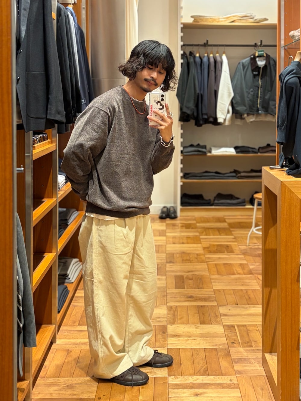 ホワイト系のその他パンツ、ブラウン系のニット/セーター、ブラウン系のスニーカーを着用したメンズの秋コーディネートの2枚目の写真