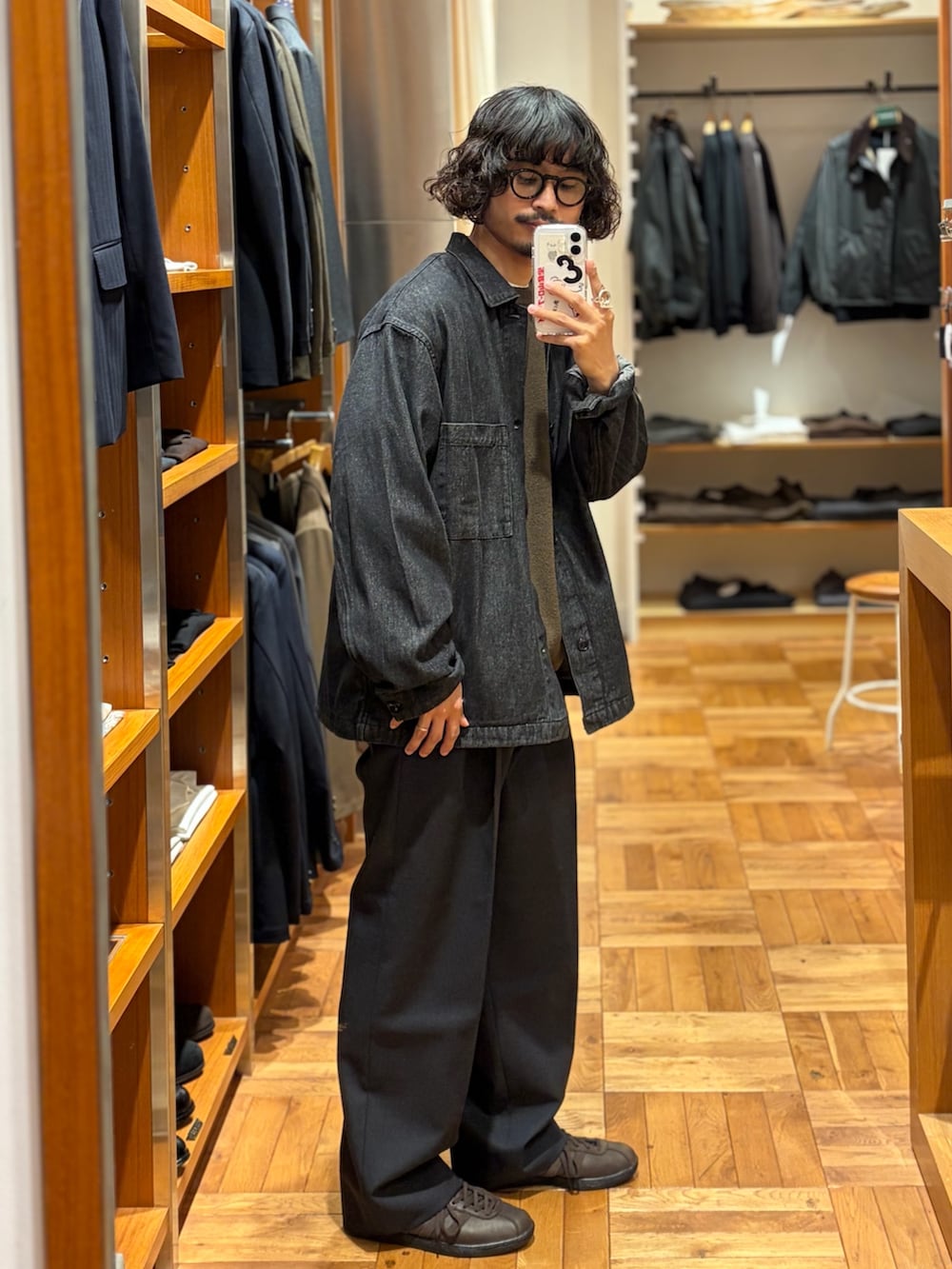 ブラック系のデニムジャケット、ブラウン系のニット/セーター、グレー系のその他パンツを着用したメンズの秋コーディネートの2枚目の写真