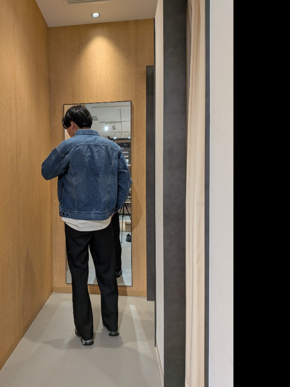 ブルー系のデニムジャケット、ホワイト系のTシャツ/カットソー、ブラック系のスニーカーを着用したメンズの冬コーディネートの3枚目の写真