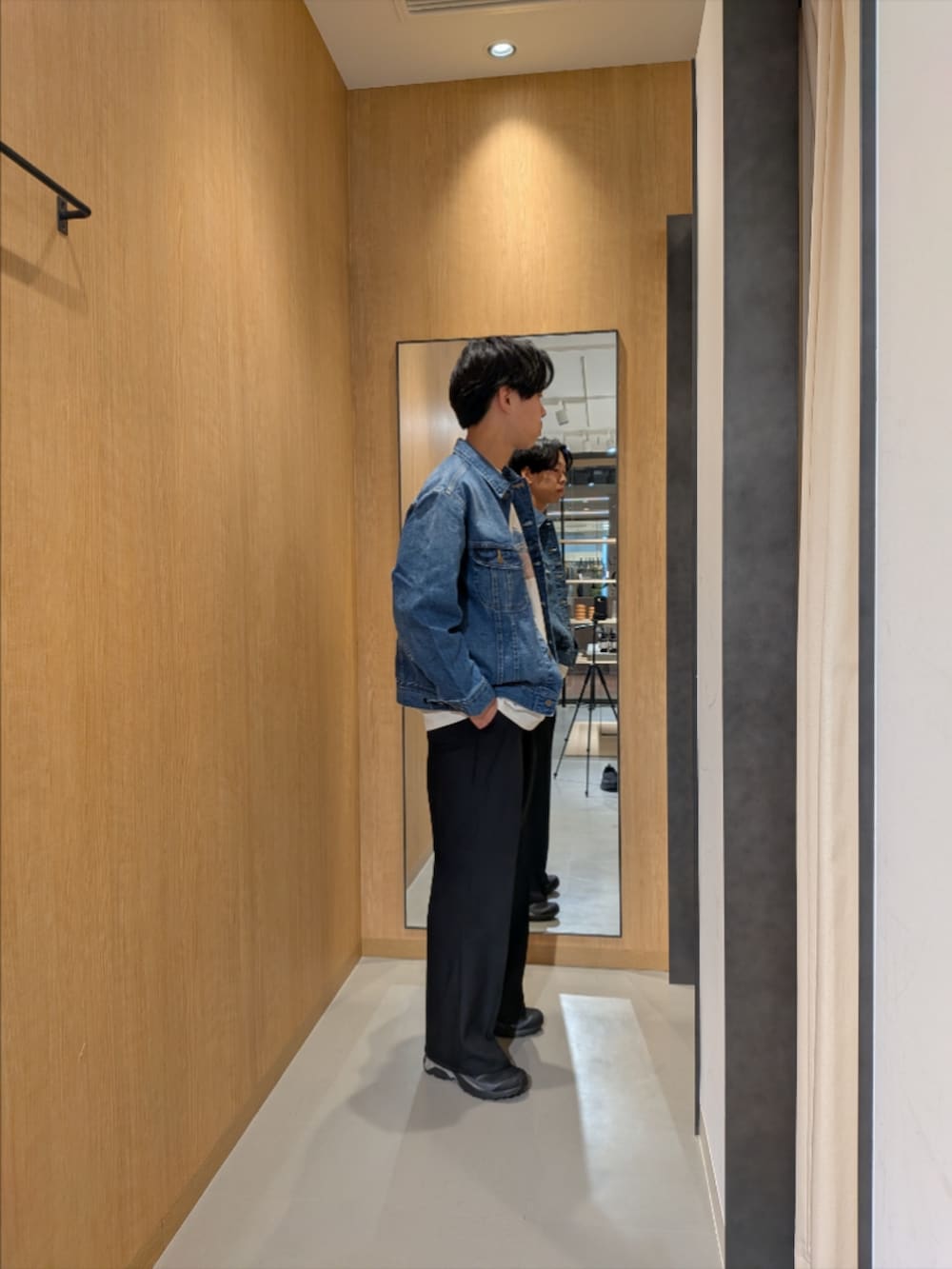 ブルー系のデニムジャケット、ホワイト系のTシャツ/カットソー、ブラック系のスニーカーを着用したメンズの冬コーディネートの2枚目の写真