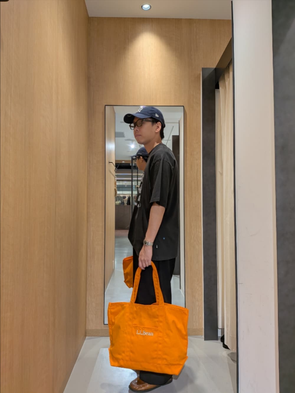 グレー系のTシャツ/カットソー、オレンジ系のトートバッグ、ブラック系のサングラスを着用したメンズの夏コーディネートの3枚目の写真