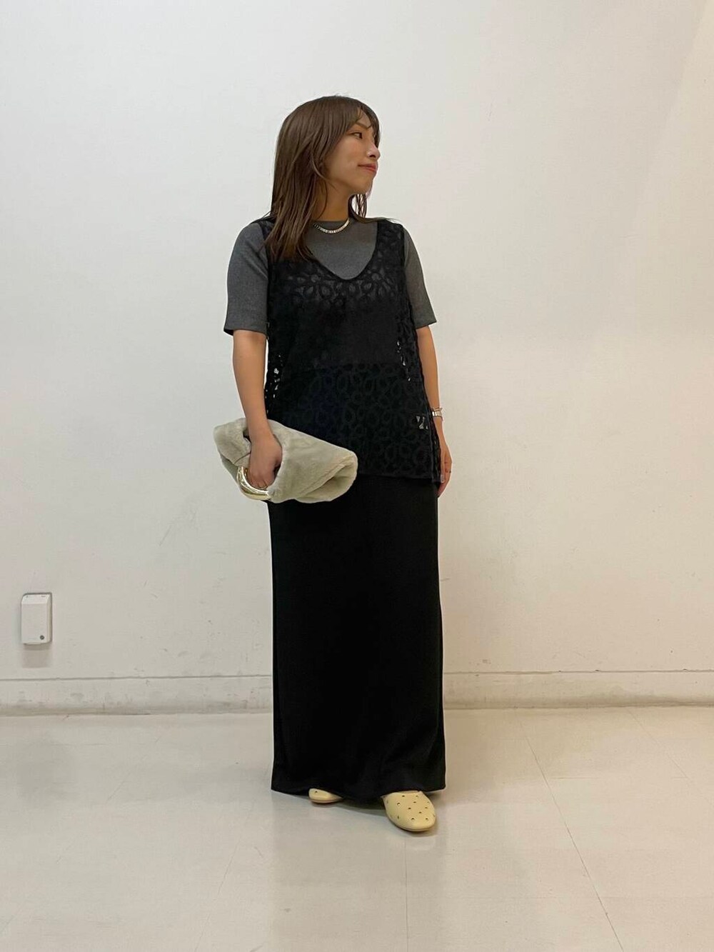 ベージュ系のパンプス、ブラック系のスカート、グレー系のニット/セーターを着用したレディースの夏コーディネートの3枚目の写真