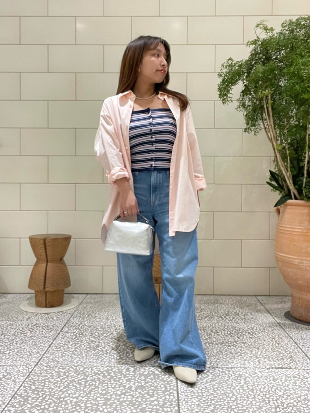 ブルー系のニット/セーター、ピンク系のシャツ/ブラウス、ブルー系のデニムパンツを着用したレディースの冬コーディネートの3枚目の写真