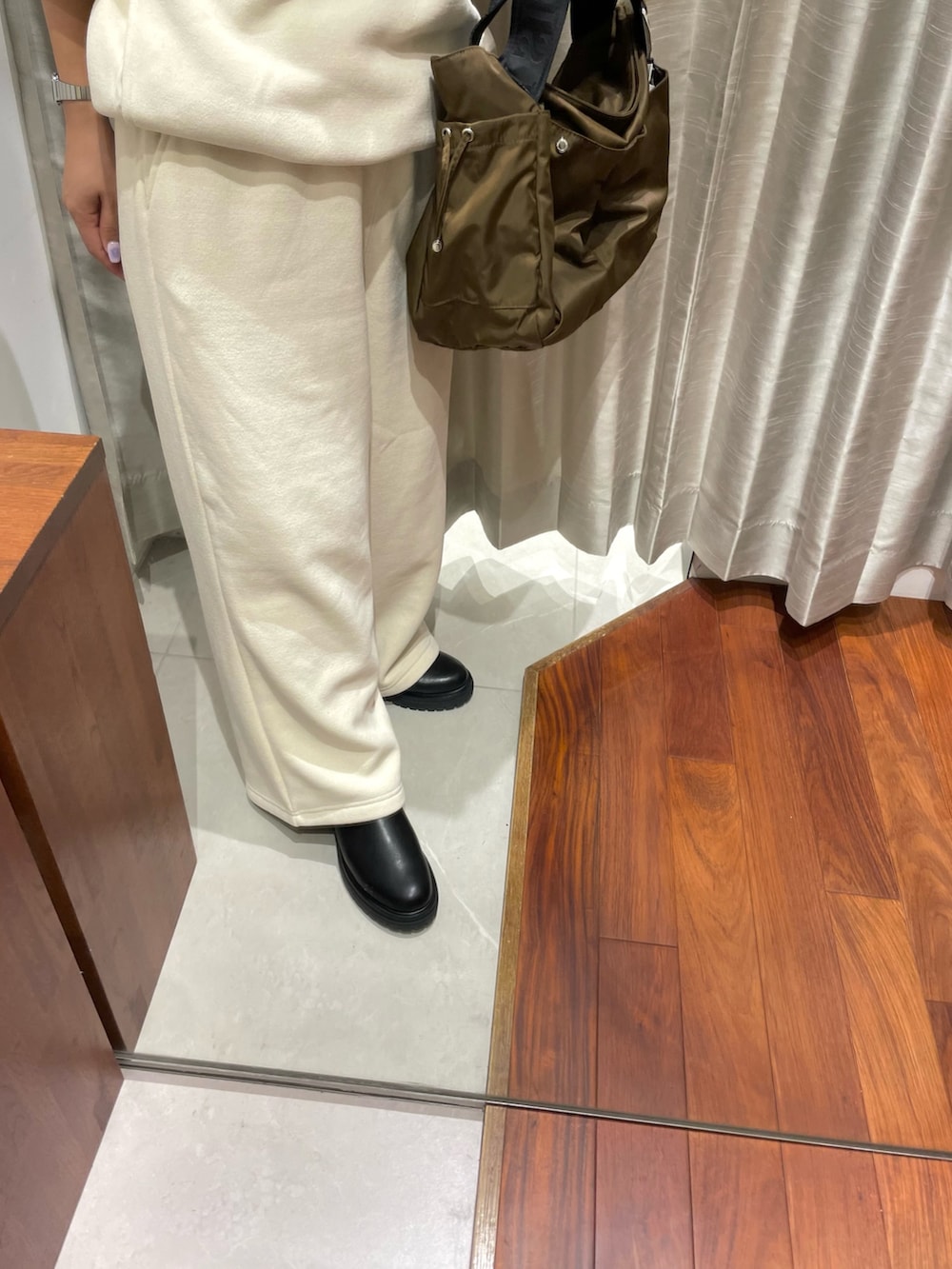 ホワイト系のパーカー、ホワイト系のその他パンツ、ブラック系のブーツを着用したレディースの秋コーディネートの2枚目の写真