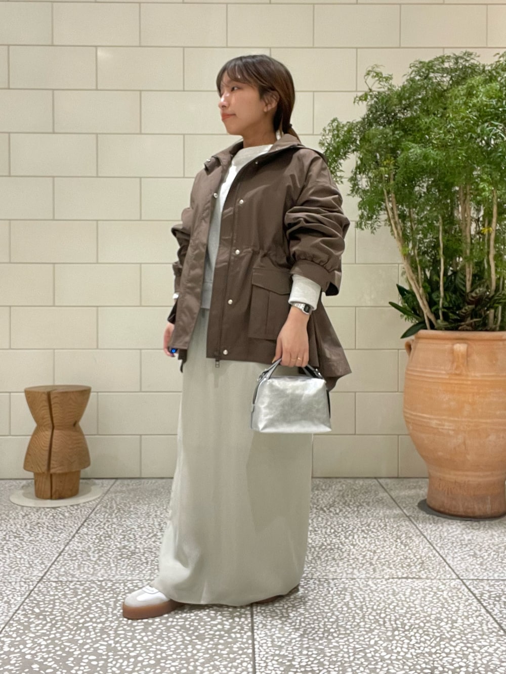 ホワイト系のスウェット、ブラウン系のブルゾン、ベージュ系のスカートを着用したレディースの冬コーディネートの2枚目の写真