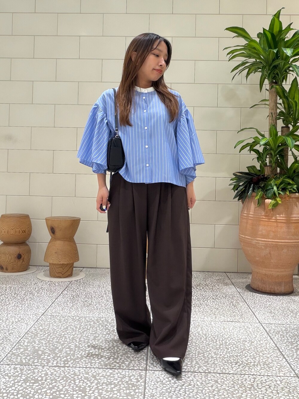 ブルー系のシャツ/ブラウス、ブラウン系のその他パンツ、ブラック系のショルダーバッグを着用したレディースの春コーディネートの3枚目の写真