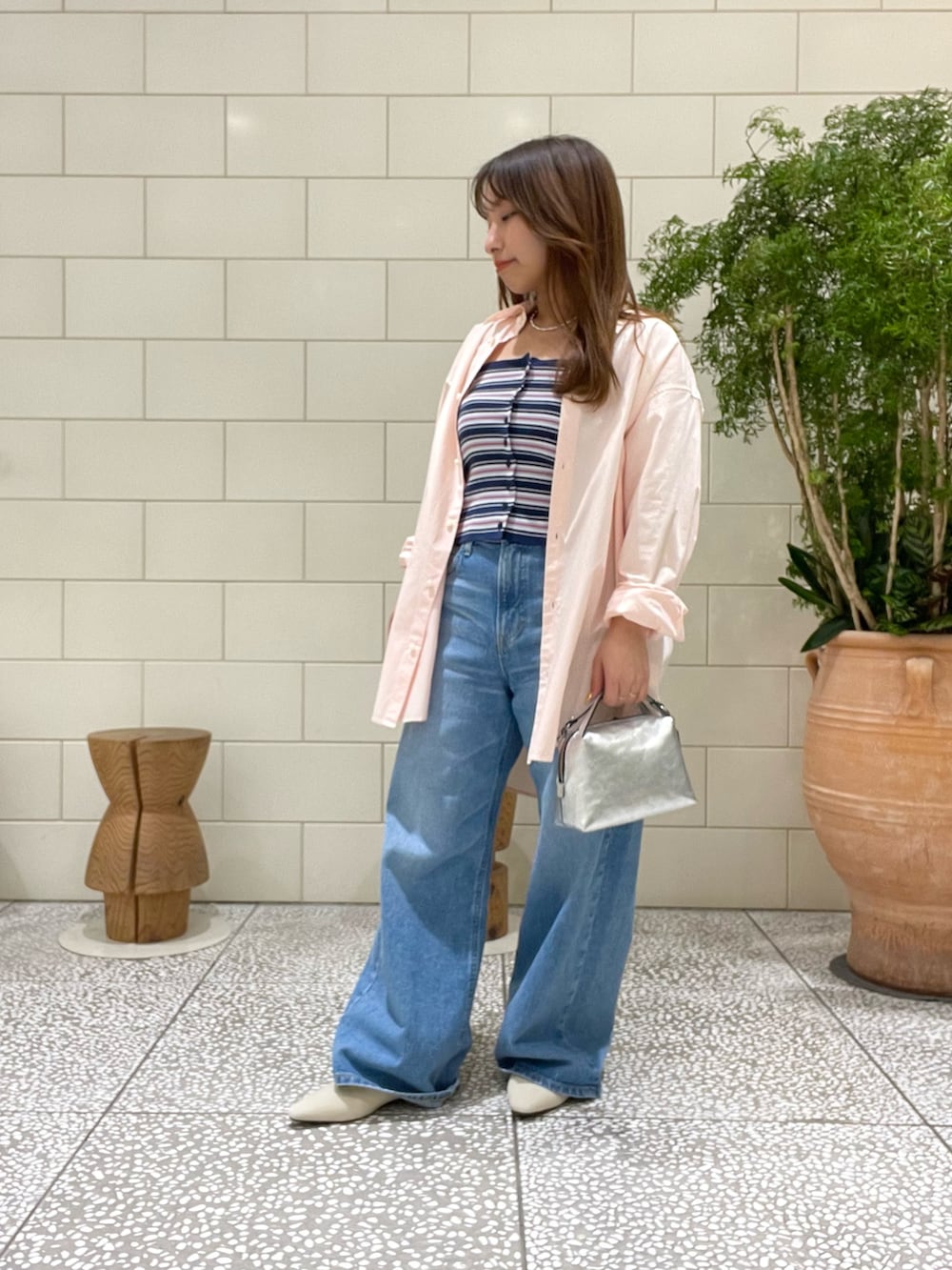 ブルー系のニット/セーター、ピンク系のシャツ/ブラウス、ブルー系のデニムパンツを着用したレディースの冬コーディネートの2枚目の写真