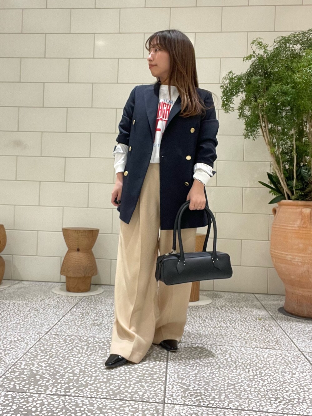 ブルー系のその他アウター、ホワイト系のTシャツ/カットソー、ブラック系のハンドバッグを着用したレディースの冬コーディネートの2枚目の写真