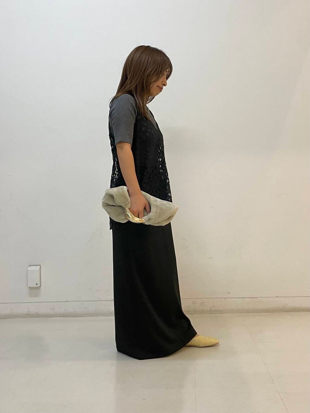 ベージュ系のパンプス、ブラック系のスカート、グレー系のニット/セーターを着用したレディースの夏コーディネートの2枚目の写真