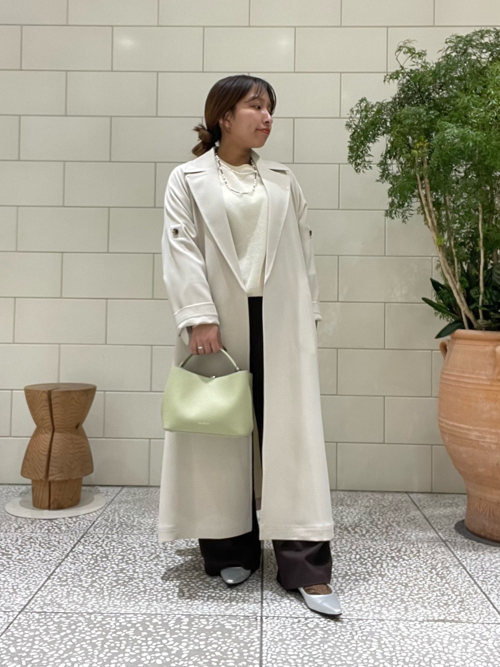 ブラウン系のその他パンツ、ホワイト系のトレンチコート、ホワイト系のニット/セーターを着用したレディースの冬コーディネートの2枚目の写真