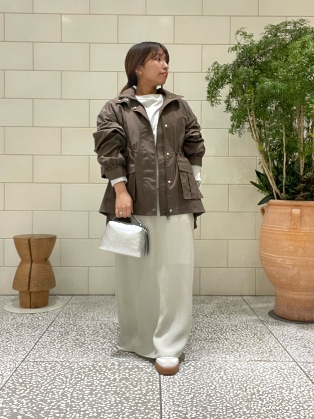 ホワイト系のスウェット、ブラウン系のブルゾン、ベージュ系のスカートを着用したレディースの冬コーディネートの3枚目の写真