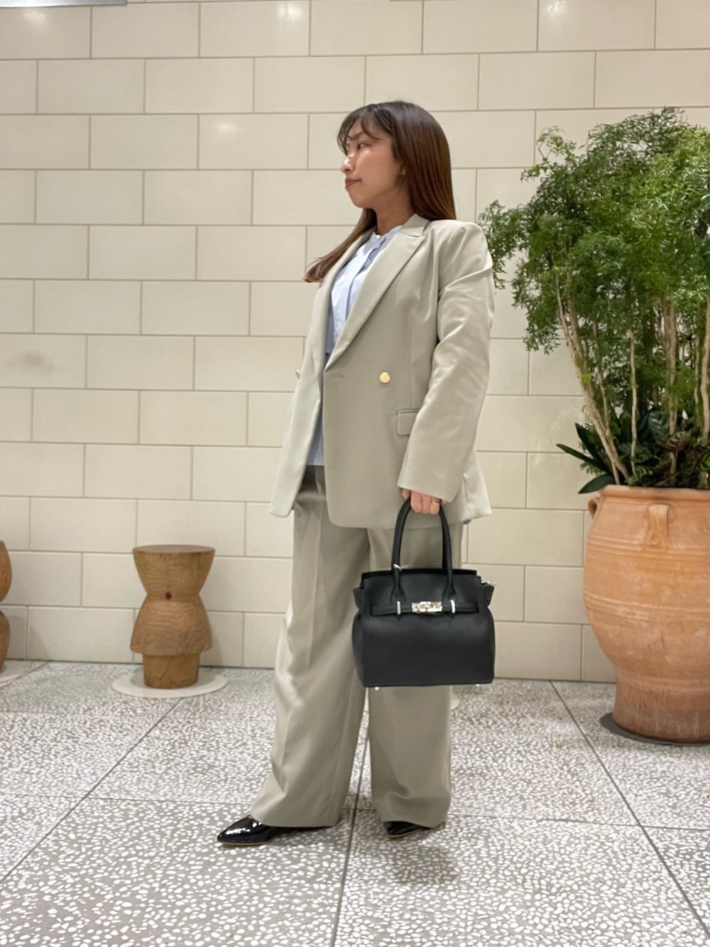 ベージュ系のその他アウター、ブルー系のシャツ/ブラウス、ブラック系のハンドバッグを着用したレディースの冬コーディネートの2枚目の写真