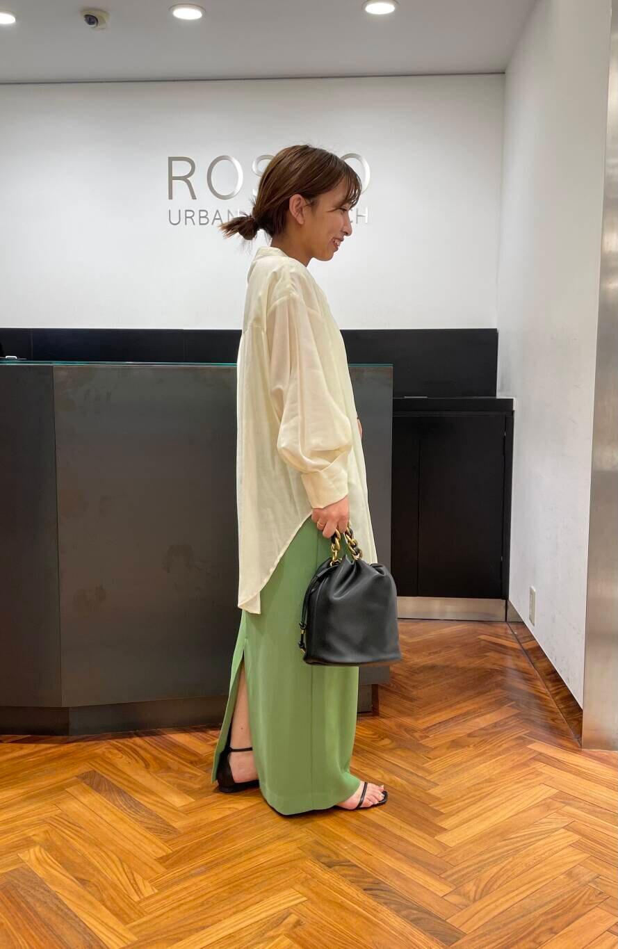 グリーン系のスカート、ブラック系のショルダーバッグを着用したレディースの夏コーディネートの2枚目の写真