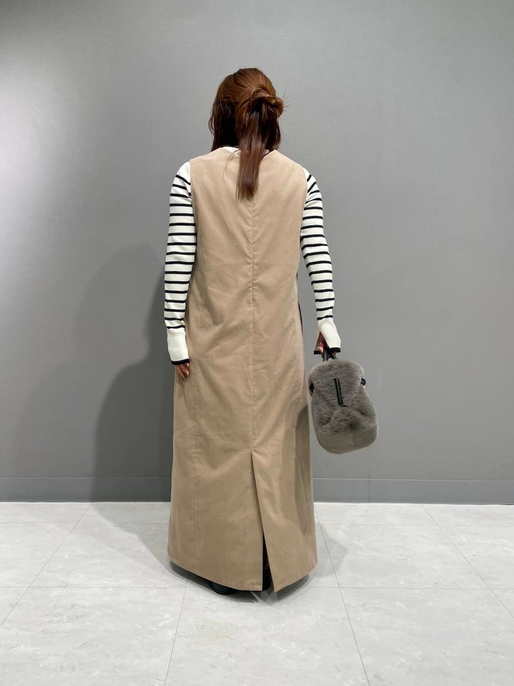 ホワイト系のニット/セーター、ベージュ系のワンピース、ブラック系のブーツを着用したレディースの秋コーディネートの3枚目の写真