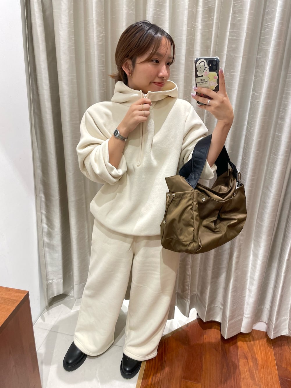 ホワイト系のパーカー、ホワイト系のその他パンツ、ブラック系のブーツを着用したレディースの秋コーディネートの3枚目の写真