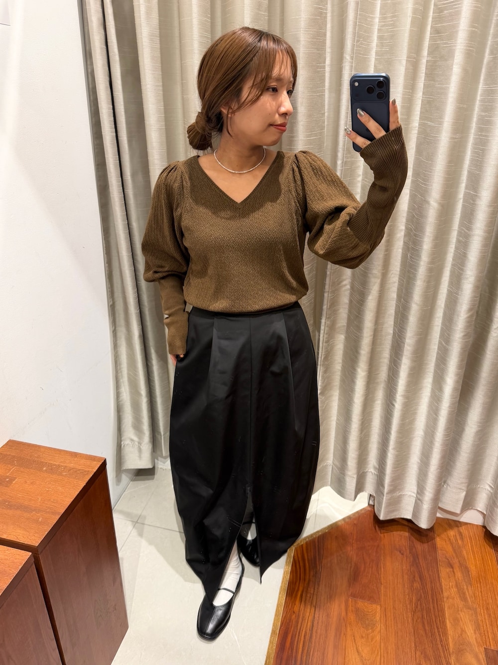 ブラック系のスカート、ブラック系のバレエシューズ、ブラウン系のニット/セーターを着用したレディースの秋コーディネートの3枚目の写真