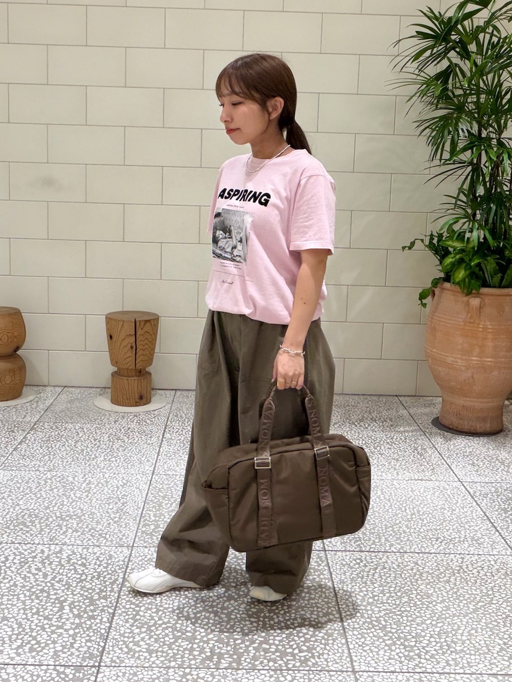 ピンク系のTシャツ/カットソー、グリーン系のその他パンツ、ブラウン系のボストンバッグを着用したレディースの夏コーディネートの2枚目の写真