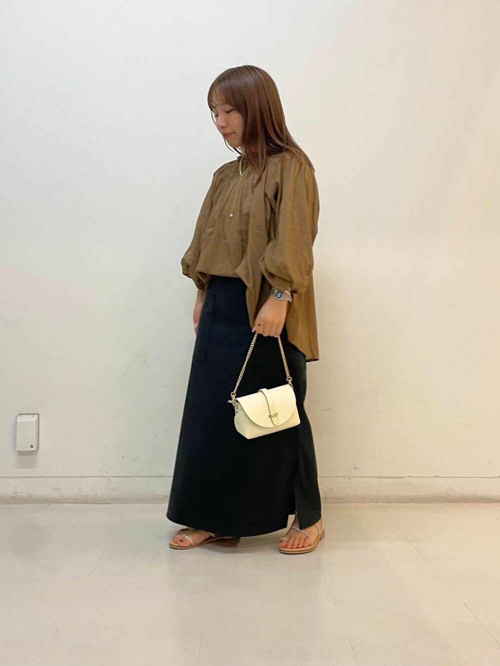 ホワイト系のショルダーバッグ、ブラック系のスカート、ブラウン系のシャツ/ブラウスを着用したレディースの夏コーディネートの3枚目の写真