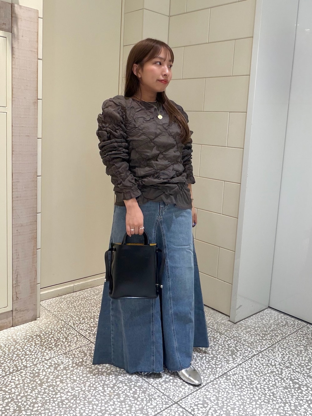 ブルー系のスカート、グレー系のその他トップス、ブラック系のショルダーバッグを着用したレディースの夏コーディネートの2枚目の写真