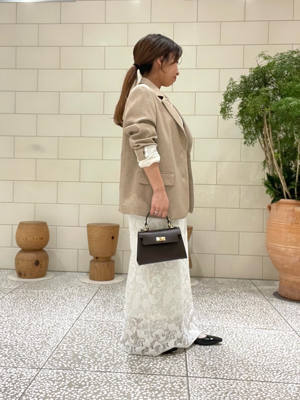 ベージュ系のその他アウター、ホワイト系のその他トップス、ホワイト系のスカートを着用したレディースの春コーディネートの3枚目の写真